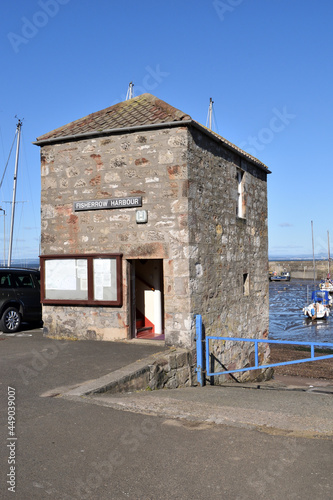 View of Old Stone Building beside Harbour against Blue Sky