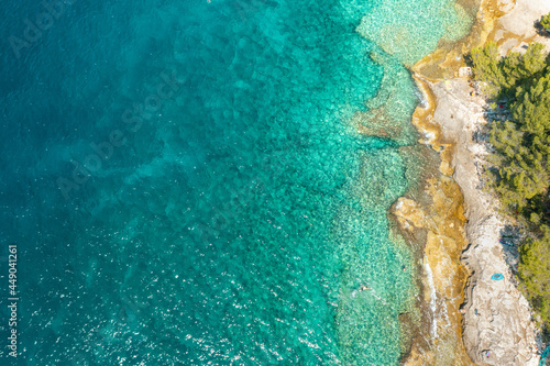 Top view of rocky shore in turquoise blue water of Adriatic Sea with copy space.