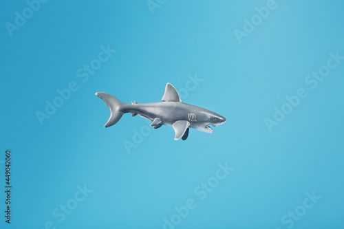 Toothy shark toy on a blue background with free space.