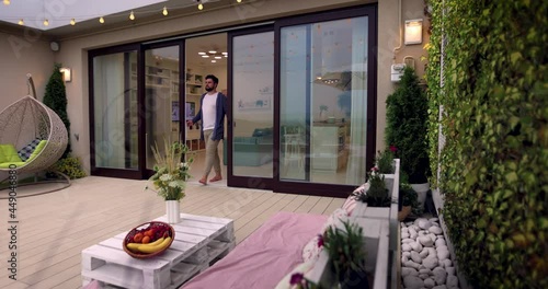 Wallpaper Mural man opens wooden sliding doors, going out on rooftop patio with cozy lounge zone Torontodigital.ca