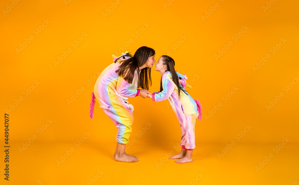 funny girls in plush costumes hug on a yellow background with a place for text