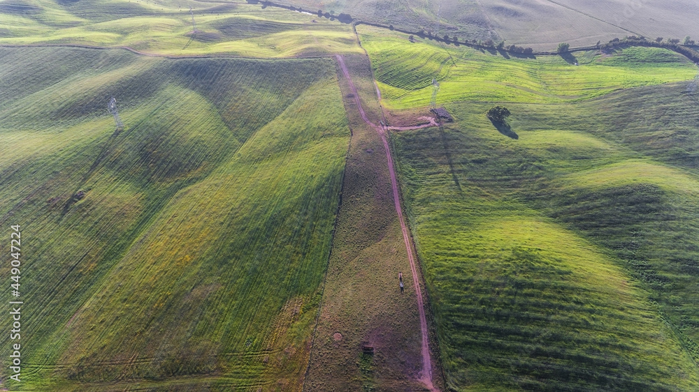 Φωτογραφία Aerial footage of the pasture. Green hills and roads. Nature.