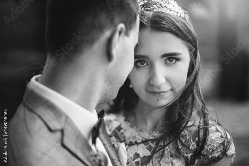 Portraits of beautiful sensual wedding couple gently hugging in european city. Stylish bride and groom kissing and embracing on background of old church. Romantic moment. Provence wedding