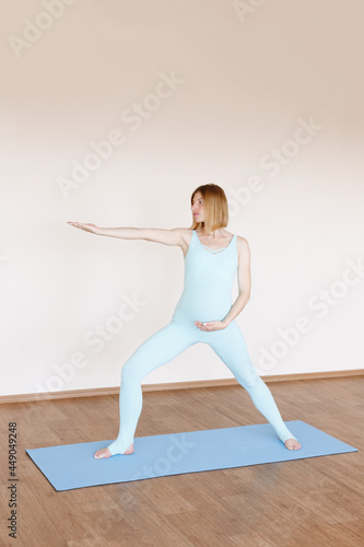 a pregnant woman practices yoga in the studio