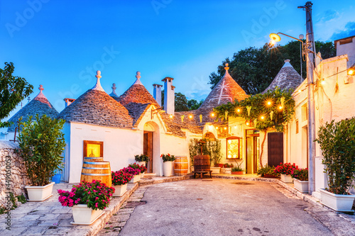 Quadro su tela Famous Trulli Houses in Alberobello Illuminated at Dusk, Puglia