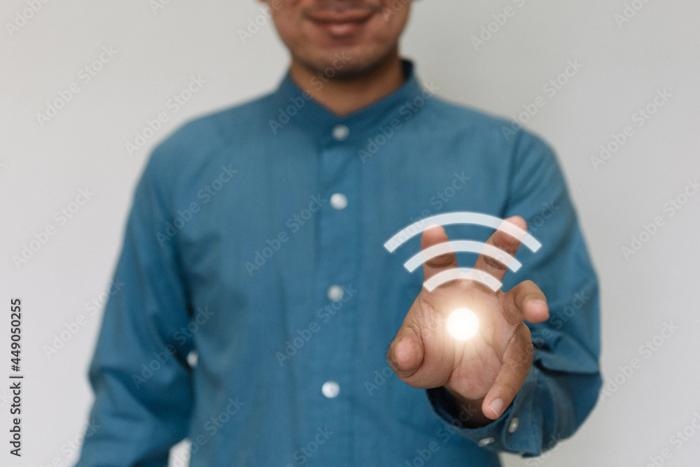 Young handsome wearing a light blue shirt turn on wifi and connected to Wi-Fi technology for using smart home function. Technology business and modern lifestyle concept. Young handsome wearing a light blue shirt turn on wifi and connected to Wi-Fi technology for using smart home function. Technology business and modern lifestyle concept.