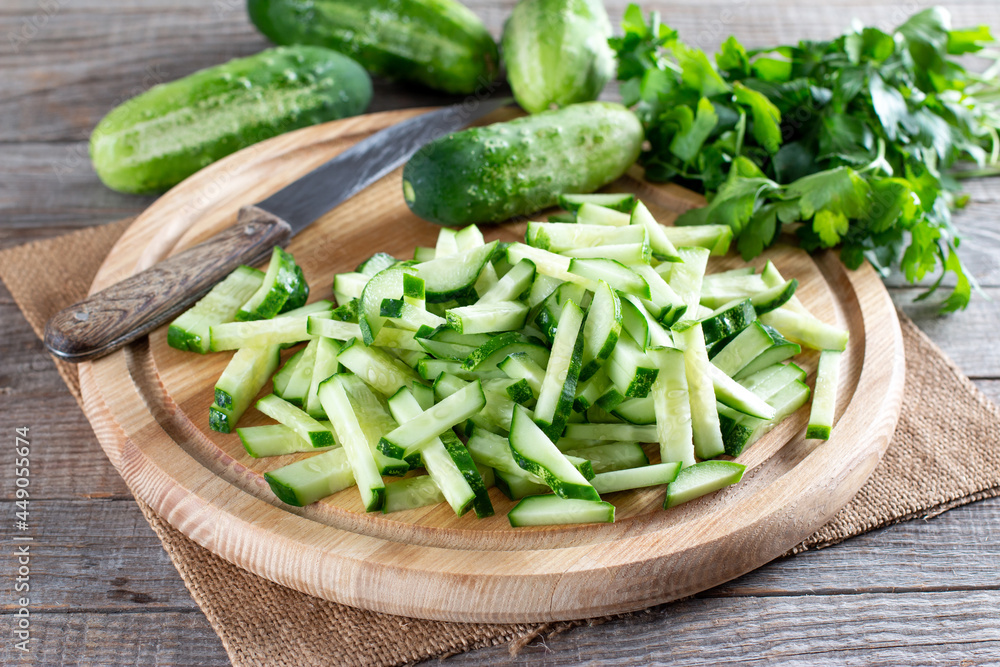 Fresh sliced green cucumbers on a cutting board on a table. Healthy vegetarian ingredient Fresh sliced green cucumbers on a cutting board on a table. Healthy vegetarian ingredient