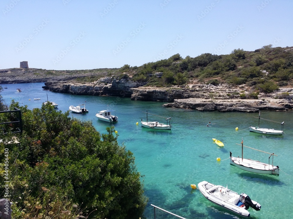 Clear blue sky / boats floating on the water / sunny day / swimming / Minorca / Menorca / holiday in Spain / peaceful scenery / rocks and trees 