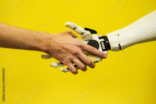 a man shakes hands with a robot close-up. engineer to create a robot. future robotics concept photo
