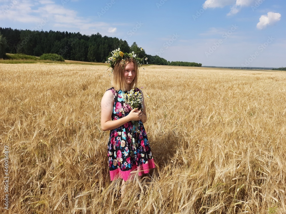 a girl in a dress and a wreath is standing in a field with a bouquet
a girl in a dress and a wreath is standing in a field with a bouquet