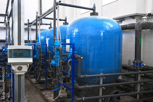 blue water tanks inside wastewater treatment facility with sensors, industrial interior