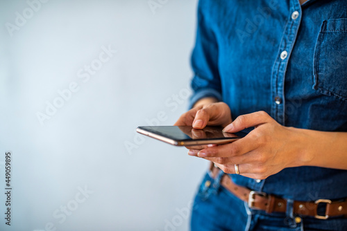 Tablou pe pânză Young woman using cell phone to send text message on social network