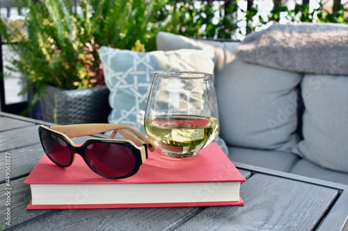 Cozy sheltered patio deck for relaxing with a book and glass of wine on hot days in beautiful lanai with Caribbean or New Orleans decor style. photo