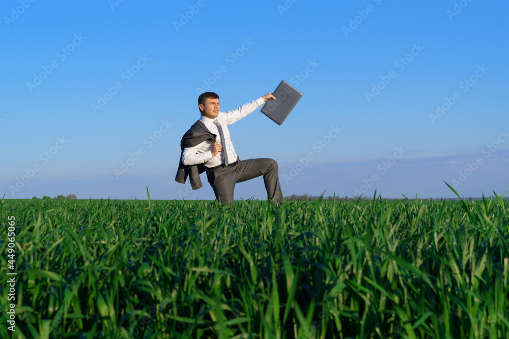 businessman works in a green field, freelance and business concept, green grass and blue sky as background