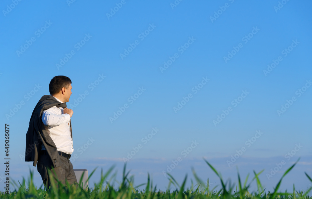 businessman works in a green field, freelance and business concept, green grass and blue sky as background businessman works in a green field, freelance and business concept, green grass and blue sky as background