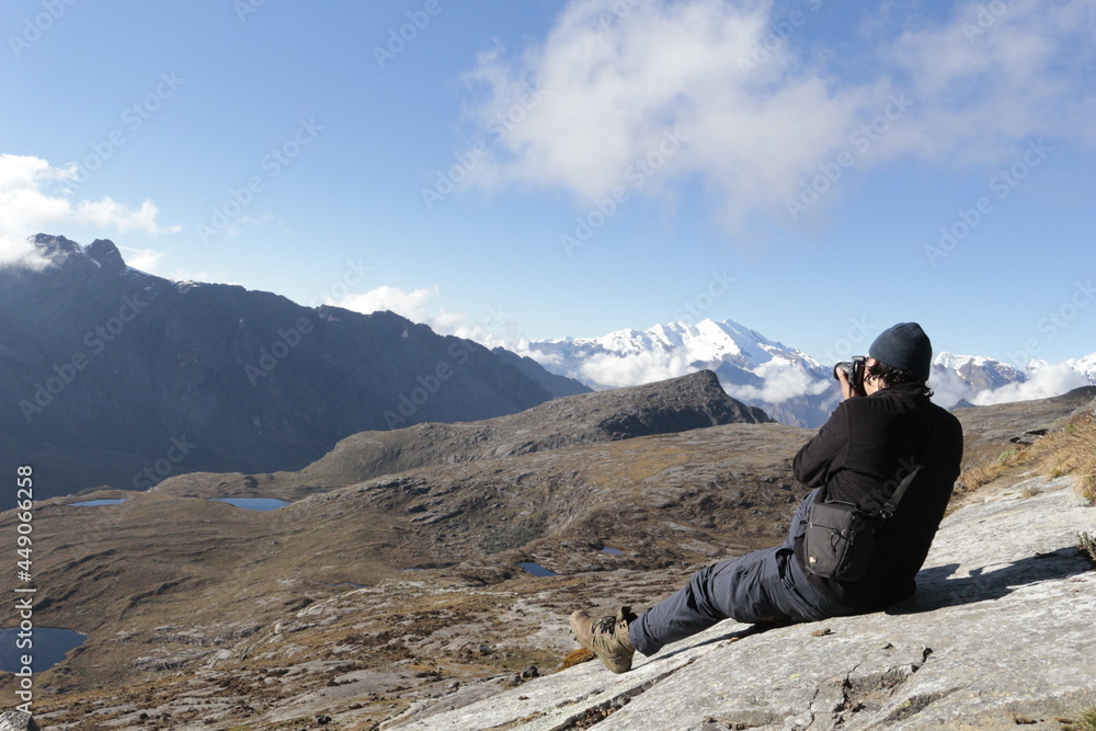 Hombre fotografiando paisaje de nevados y motañas