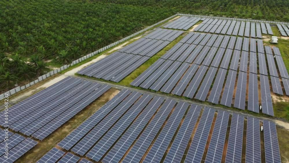 Aerial rotating view solar panel near oil palm plantation Aerial rotating view solar panel near oil palm plantation
