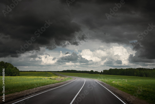 Summer country road before thunder storm. Dramatic sky.