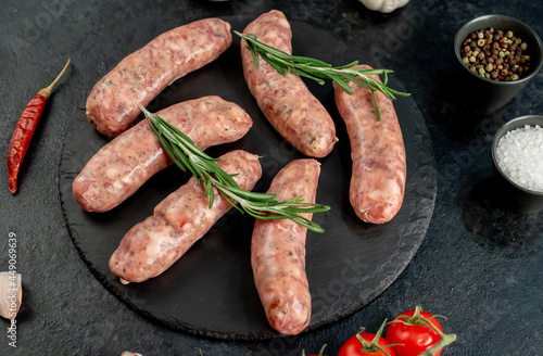  raw sausages for grilling on a stone background