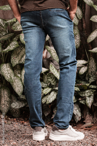 Męskie spodnie jeans niebieskie na modelu na naturalnym tle, zdjęcie reklamowe na baner. © insomniafoto