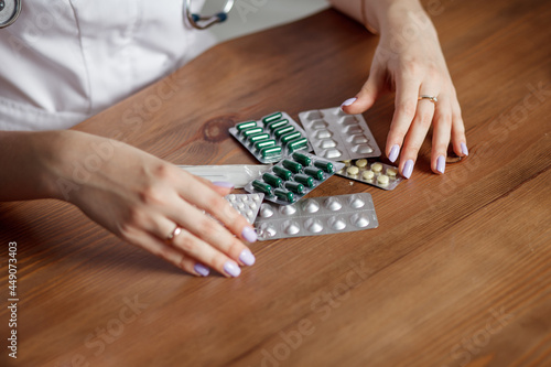 Medicines on a wooden table in the hands of a doctor. Space for text.