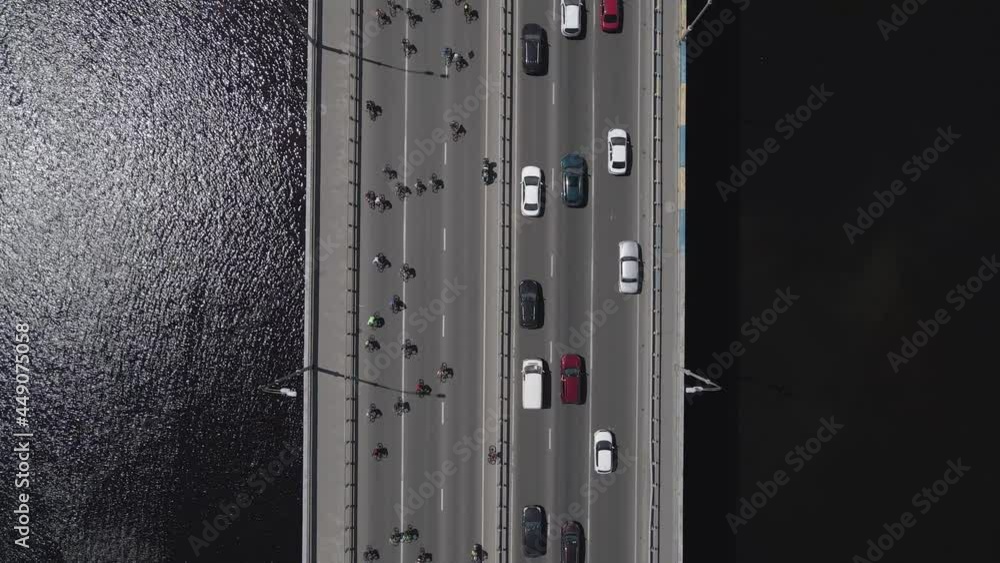 Aerial view from a drone to a group of cyclists on bicycles ride on the road with traffic Aerial view from a drone to a group of cyclists on bicycles ride on the road with traffic