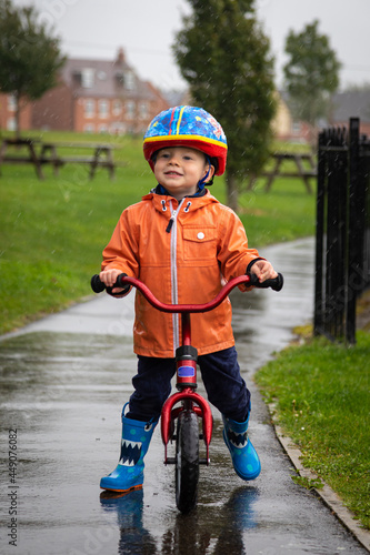 Fototapeta Naklejka Na Ścianę i Meble -  Boy riding a bike in the rain