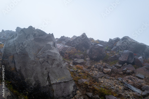 栃木県那須郡那須町の那須岳に霧の中で紅葉を見るために登山している風景 A view of climbing Mt. Nasu in Nasu-machi, Nasu-gun, Tochigi Prefecture, to see the autumn leaves in the fog. photo