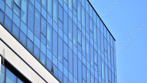 Futuristic facade of a modern office building clad in glass. Glass cladding panels and windows of modern building. An office building with geometry and perspective.