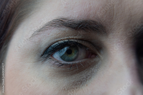 Ojo verde de una mujer de piel blanca, ojo mirándome, primer plano del iris  photo
