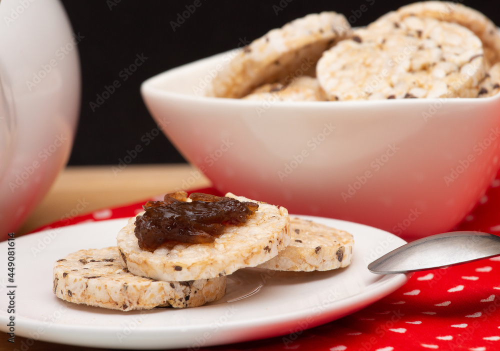 close up of a plate with rice vegan cookies with jelly on the top beside a bowl full of rice cookies close up of a plate with rice vegan cookies with jelly on the top beside a bowl full of rice cookies