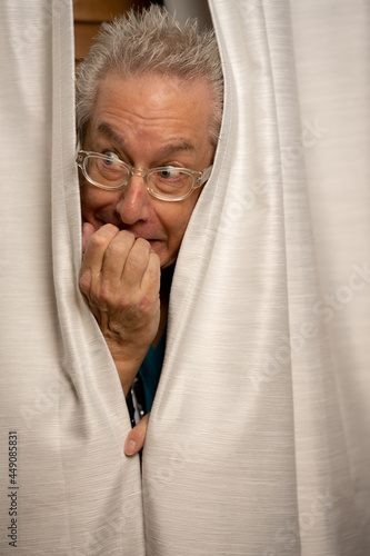 Photo of a doctor hiding in his office behind the curtains photo