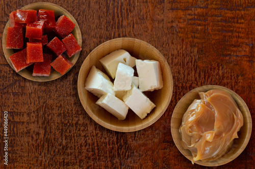 Dulce de leche, guava and white cheese on wooden table - Brazilian desserts. Top view