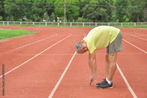 an old man warming up exercise before running or jogging, concept health care in elderly people © Verin