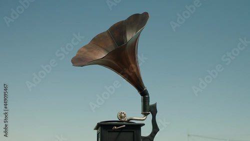 Vintage gramophone . Vintage old gramophone plays a vinyl record on a Sunny day . Outdoor wooden case turntable . Vinyl phonograph . Shot on ARRI ALEXA Cinema Camera in slow motion .