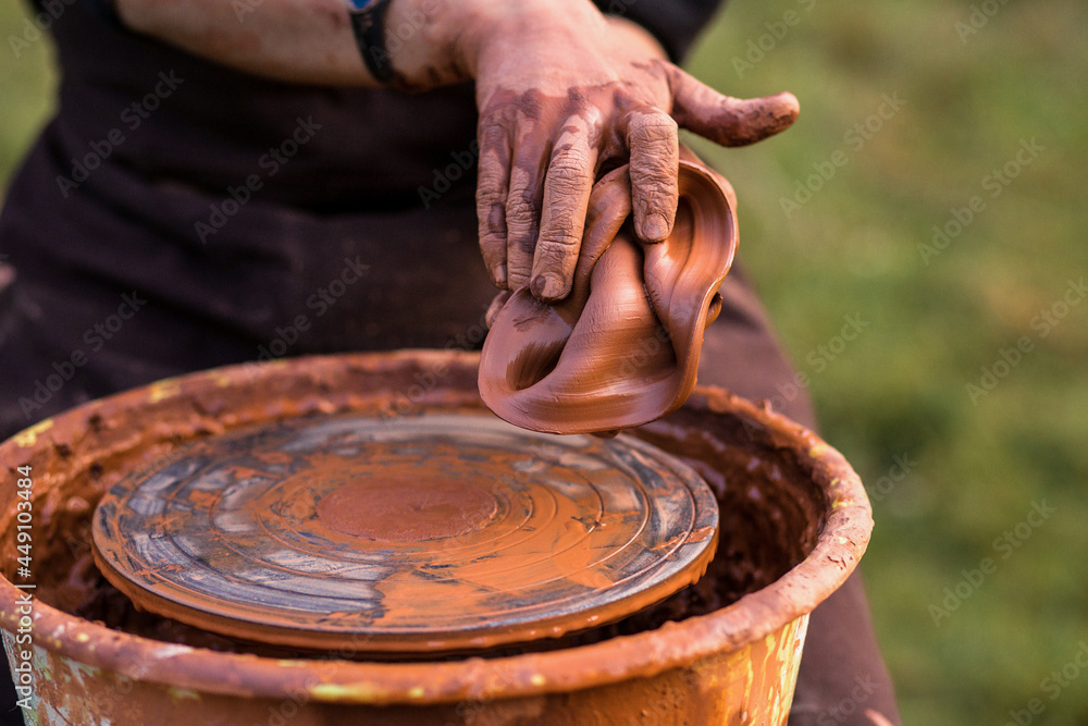 Selective focus. Sculptor man hands ruined a clay vase working by potter wheel