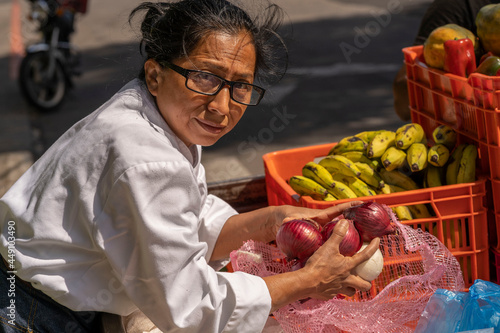 Latin woman buying onions in street. Buying onions in street sale