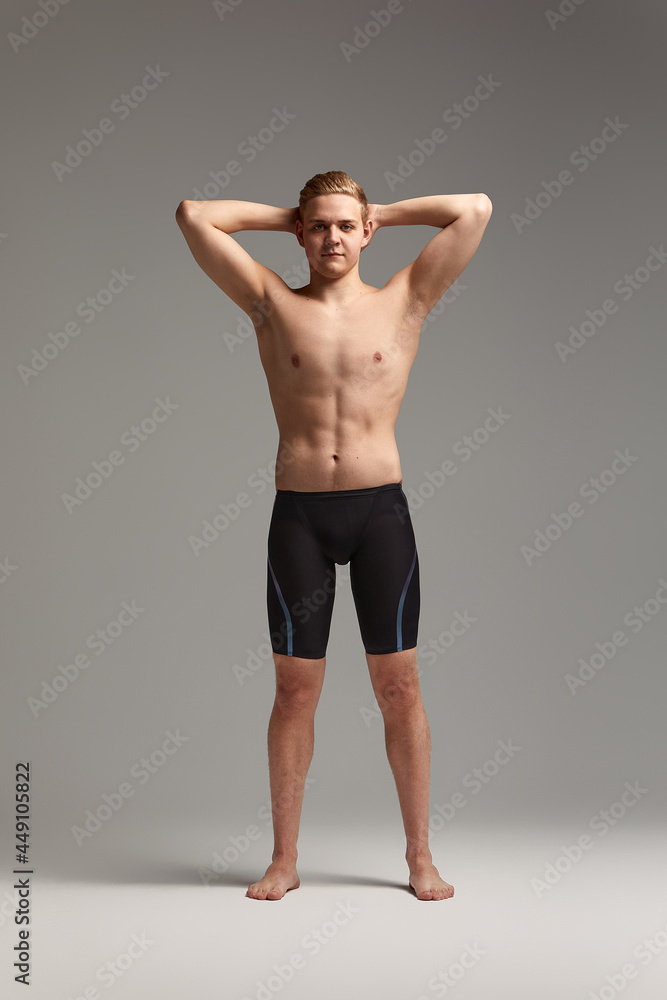 Portrait of a swimmer in a cap and mask, half-length portrait, young athlete swimmer wearing a cap and mask for swimming, copies of space, gray background