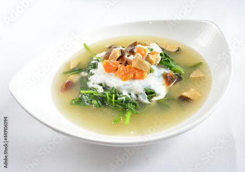 stir fried mixed vegetables spinach with 3 salted eggs in hot soup in white background asian halal menu