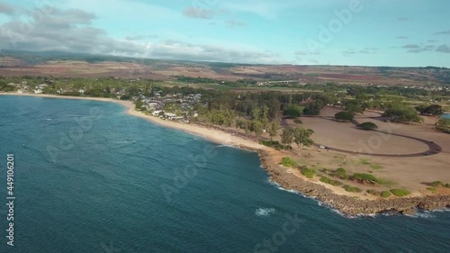 Wallpaper Mural Aerial drone shot of sunny, warm, sandy beach in Oahu Hawaii, by the water, waves crashing into sand and rocks, mountain and hills in the background over terrain on the island surrounded by sea. Torontodigital.ca