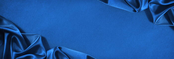 Beautiful blue silk satin background. Wavy soft folds. Elegant fabric background with copy space for design. Web banner.