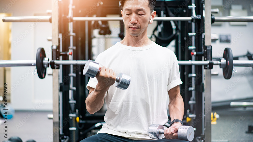 ダンベルを使って筋トレをする中年男性 ダンベルを使って筋トレをする中年男性