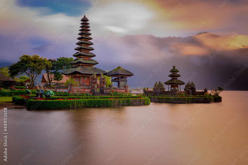 Pura Ulun Danu Bratan temple in Bali island. Beautiful balinese temple during sunrise. Balinese landmark. Cloudy sky. Water reflection. Slow shutter speed. Bratan lake, Bali