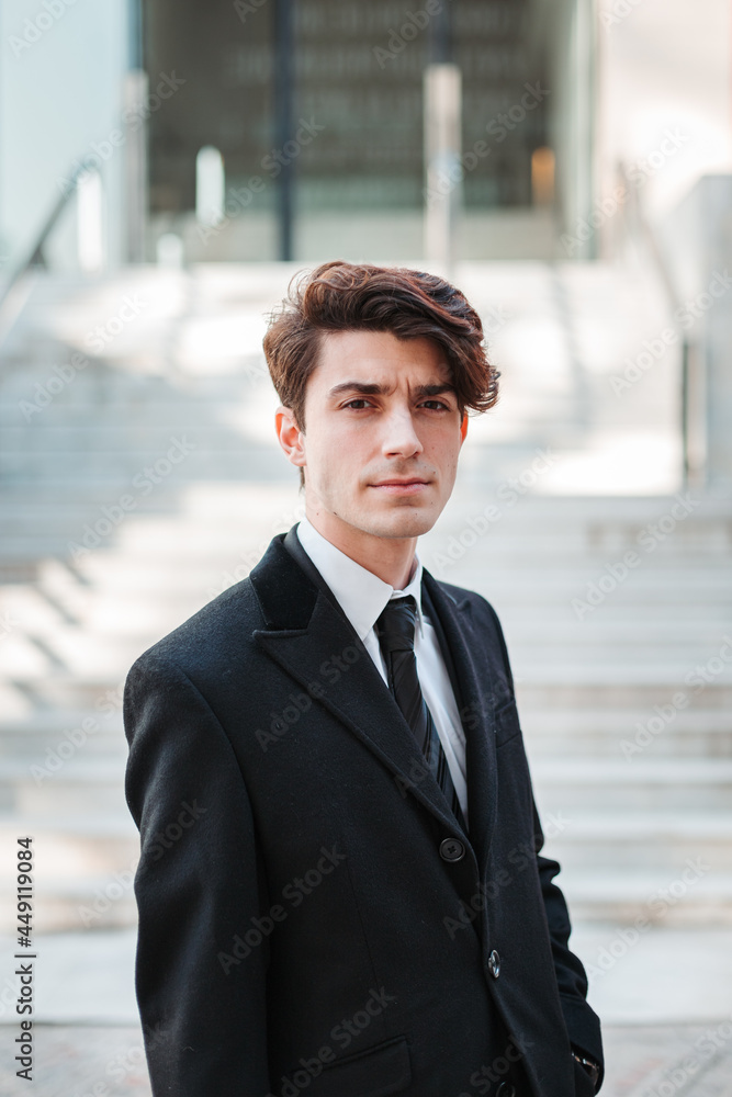 young man in casual suit walking through a place with stairs young man in casual suit walking through a place with stairs