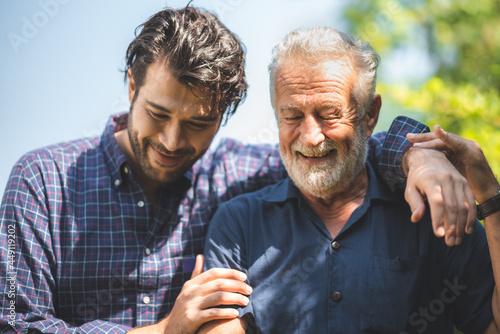 caucasian senior father and adult son are hugging together at home, generation family are happy with people love, male mature, old person man, elderly grandfather smiling living at the house photo