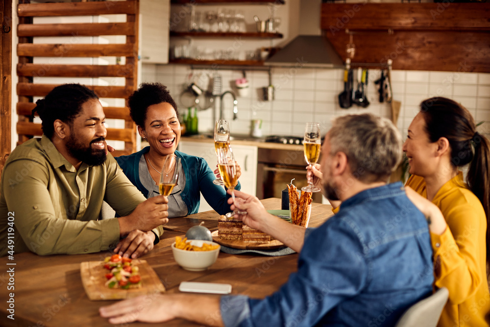 Cheerful multi-ethnic people toast with champagne at dining table. Cheerful multi-ethnic people toast with champagne at dining table.