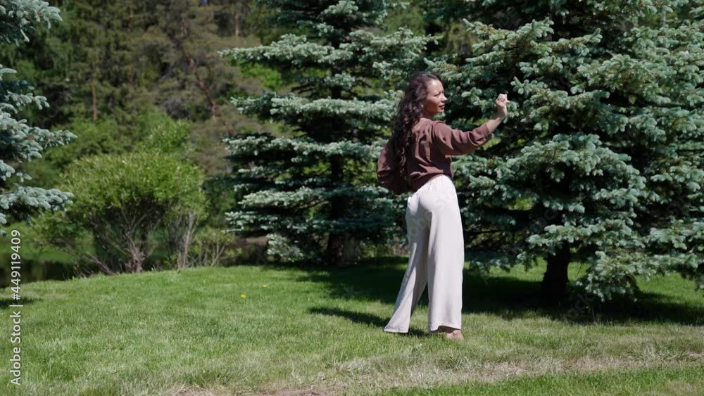 A slender hippie woman dances on the grass, in nature. Happy holiday concept, a portrait of female happiness. A slender hippie woman dances on the grass, in nature. Happy holiday concept, a portrait of female happiness.