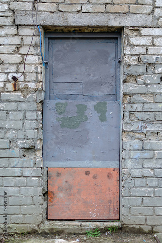 The old front door in the brick wall. A cracked front of a build © Mikhail