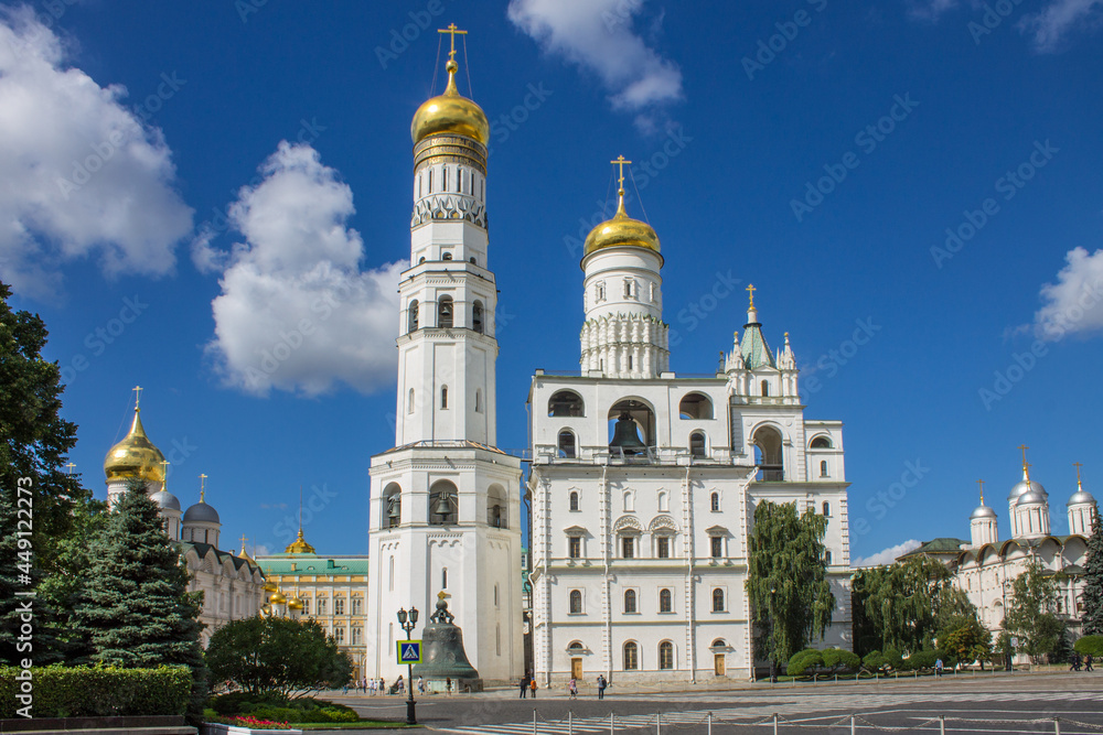 view of the white-stone bell tower of Ivan the Great with golden domes in the Kremlin on Sobornaya Square on a bright sunny summer day in Moscow Russia