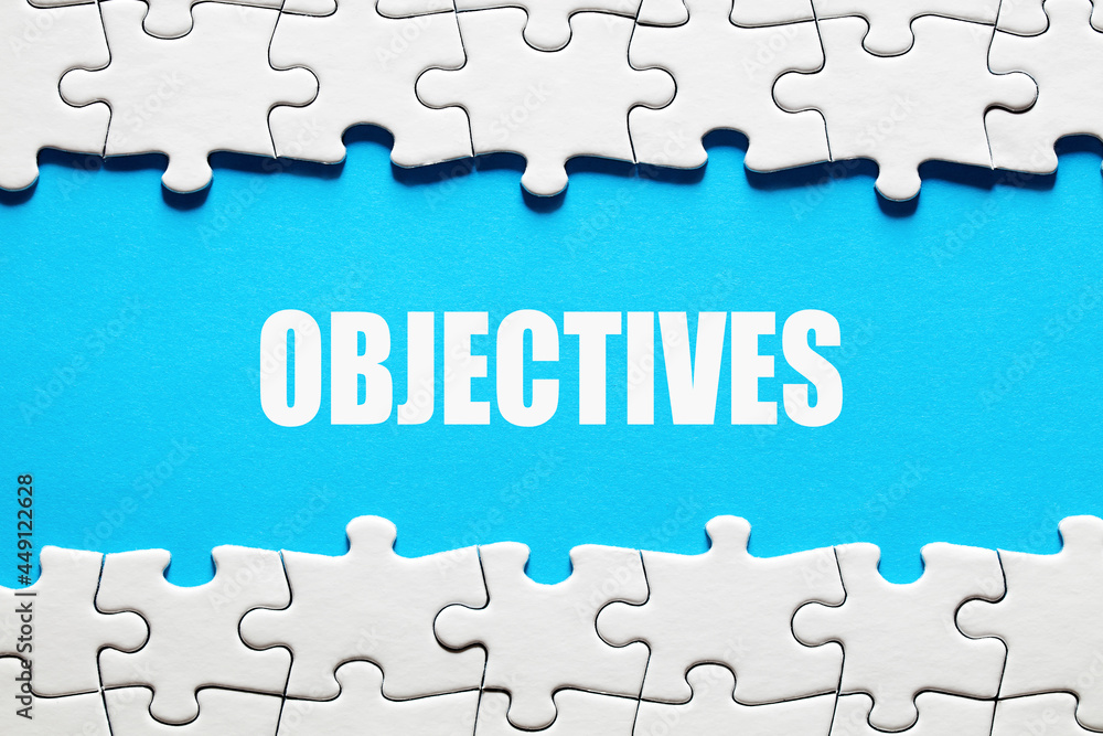 The word objectives framed by jigsaw puzzle pieces. To discover or set business or company objectives The word objectives framed by jigsaw puzzle pieces. To discover or set business or company objectives
